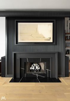 a living room with a fire place in the center and a painting on the wall