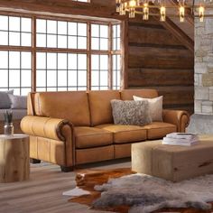 a living room filled with furniture and a chandelier hanging from the ceiling over a fire place