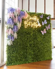 a green wall with flowers and butterflies on it that says, charlotte's birthday