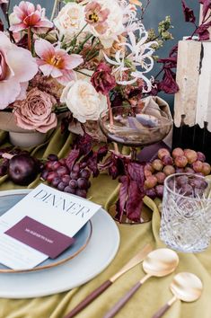 the table is set with flowers, fruit and other items for an elegant dinner party