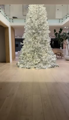 a large white christmas tree sitting in the middle of a room