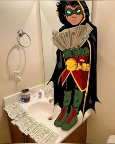 a bathroom with a sink, toilet and a batman character on the counter next to it