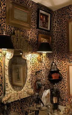 a bathroom with leopard print wallpaper and two lamps on the side table in front of it