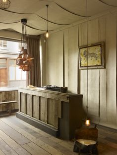 a kitchen with wooden floors and hanging lights