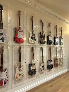 the wall is filled with guitars on display