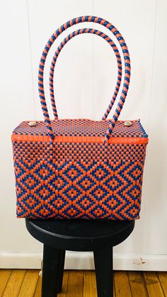 "Each bag begins in the small villages of Oaxaca, Mexico, handcrafted by creative and powerful artisans. Each bag is truly one of a kind piece. Featured in this listing is a blue and orange tote.  *Handwoven *One thick handle on each side of the bag for extra security  *Easy maintenance  *Eco-friendly *Reusable *Fashionable *Lightweight  *Waterproof *Durable Please feel free to email me if you have any questions. Thank you! Bag measurements: 11.5\" W x 8\" H x 5.5\" D with a strap drop 9.5\"" Mexican Baskets, Diy Baskets, Mexican Bag, Thank You Bags, Plastic Basket, Sweet Accessories, Disinfecting Wipes, Plastic Baskets, Bag Lunch