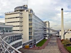 an aerial view of a large building with a walkway leading up to the top floor