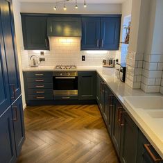 a kitchen with wooden floors and blue cabinets