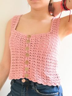 a woman wearing a pink crocheted tank top with buttons on the front and back