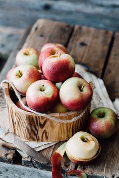 a wooden bowl filled with red and green apples