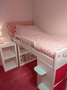 a small child's bedroom with pink carpet and white bunk bed, red drawers