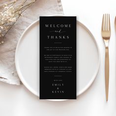 a black and white menu card on a plate next to silverware, forks and napkins