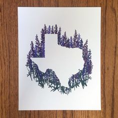 a piece of paper that has been cut into the shape of a texas map with purple flowers on it