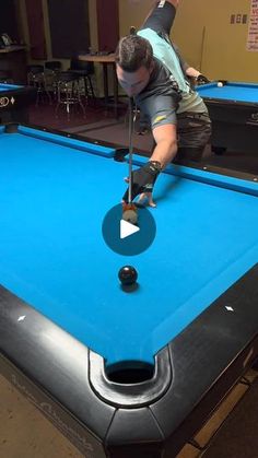 a man is playing pool on a blue table