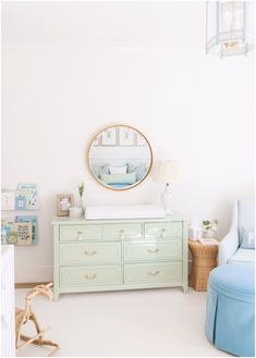 a baby's room with a dresser and mirror