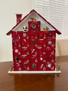 a house made out of red mail boxes with christmas decorations on the front and sides