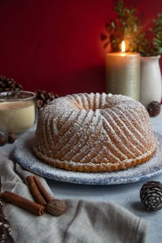 a cake sitting on top of a plate covered in powdered sugar next to candles