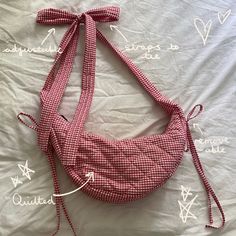 a red and white checkered handbag tied up on top of a bed with words written in cursive writing