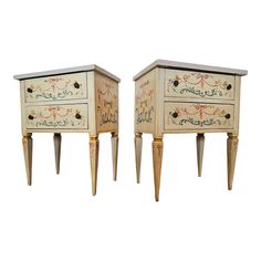 two white and gold decorated nightstands with drawers