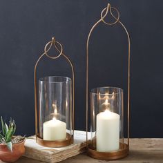 two candles are sitting in glass containers on a table