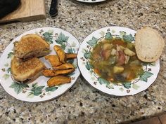 two plates with food on them sitting on a counter next to a knife and fork