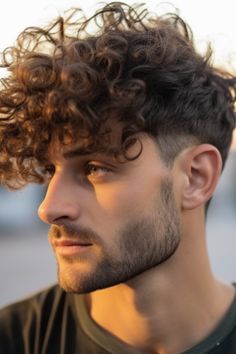 Messy curls combined with a mid-taper fade create an effortless cool vibe. This curly hairstyle is perfect for those who prefer a natural look. Click here to check out more best curly hairstyles and haircuts for men. Styling Curly Hair Men, Men’s Thick Curly Hairstyles, Curly Mens Hairstyles, Mid Taper, Best Curly Hairstyles, V Shaped Haircut, Top Haircuts For Men, Men Curly Hair, Mens Hairstyles Curly