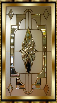 an art deco style glass door with gold trimmings and decorative designs on it