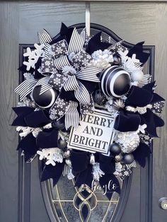 a black and white wreath on the front door with merry and bright written on it