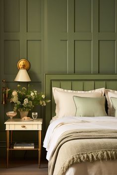 a bedroom with green paneled walls and white bedding