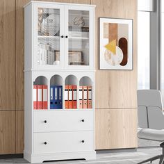 a white bookcase with books on it next to a chair