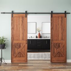 an open sliding door in the middle of a room with two sinks and a potted plant