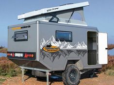 an off road camper parked on the side of a dirt road