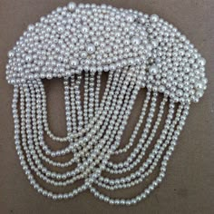 a white beaded hair comb with pearls on it