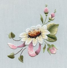 a white and pink flower with green leaves on a light blue background is embroidered onto the fabric