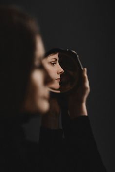 a woman looking in the mirror with her eyes closed