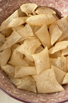 a bowl filled with potato chips on top of a table