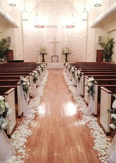 the aisle is decorated with white flowers and petals