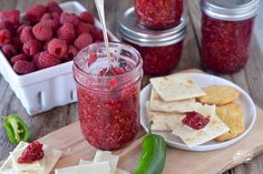 raspberry jam and crackers on a cutting board