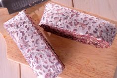 two pieces of cake sitting on top of a wooden cutting board next to a knife