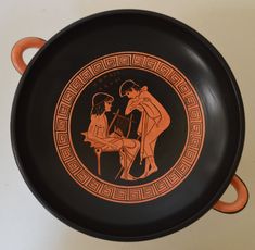 an orange and black plate with two people on it