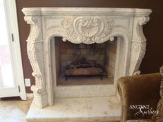 an ornate fireplace in a living room next to a chair