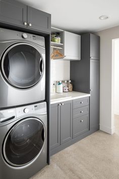 a large washer and dryer in a room with gray cabinets on the walls