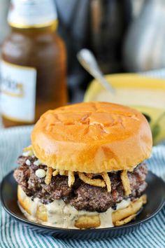 a cheeseburger with onion rings on a black plate