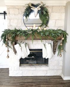 a fireplace decorated with greenery and stockings