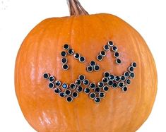 an orange pumpkin decorated with black beads