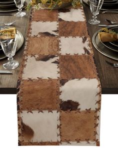 the table runner is decorated with cowhides and silverware, along with other place settings