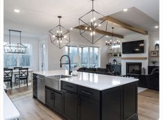 a large kitchen with an island in the middle and lots of lights hanging from the ceiling