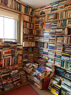 a room filled with lots of books next to a window