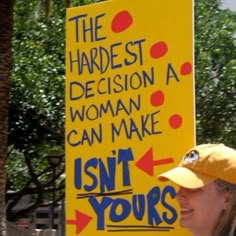 a woman standing next to a sign that says, the hardest decision a woman can make isn't yours