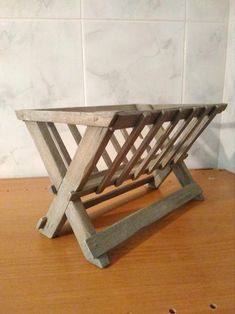 a wooden table that has some sort of rack on it's side, sitting on a wood surface